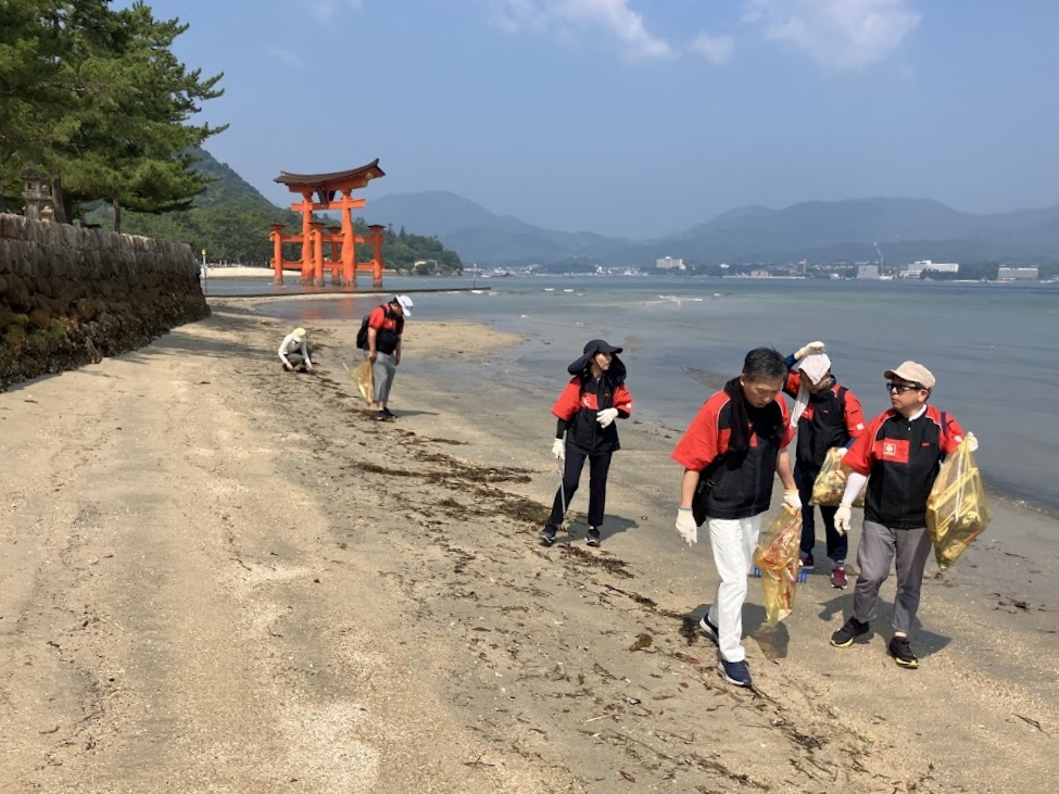 大鳥居を背景に清掃活動を行う参加者